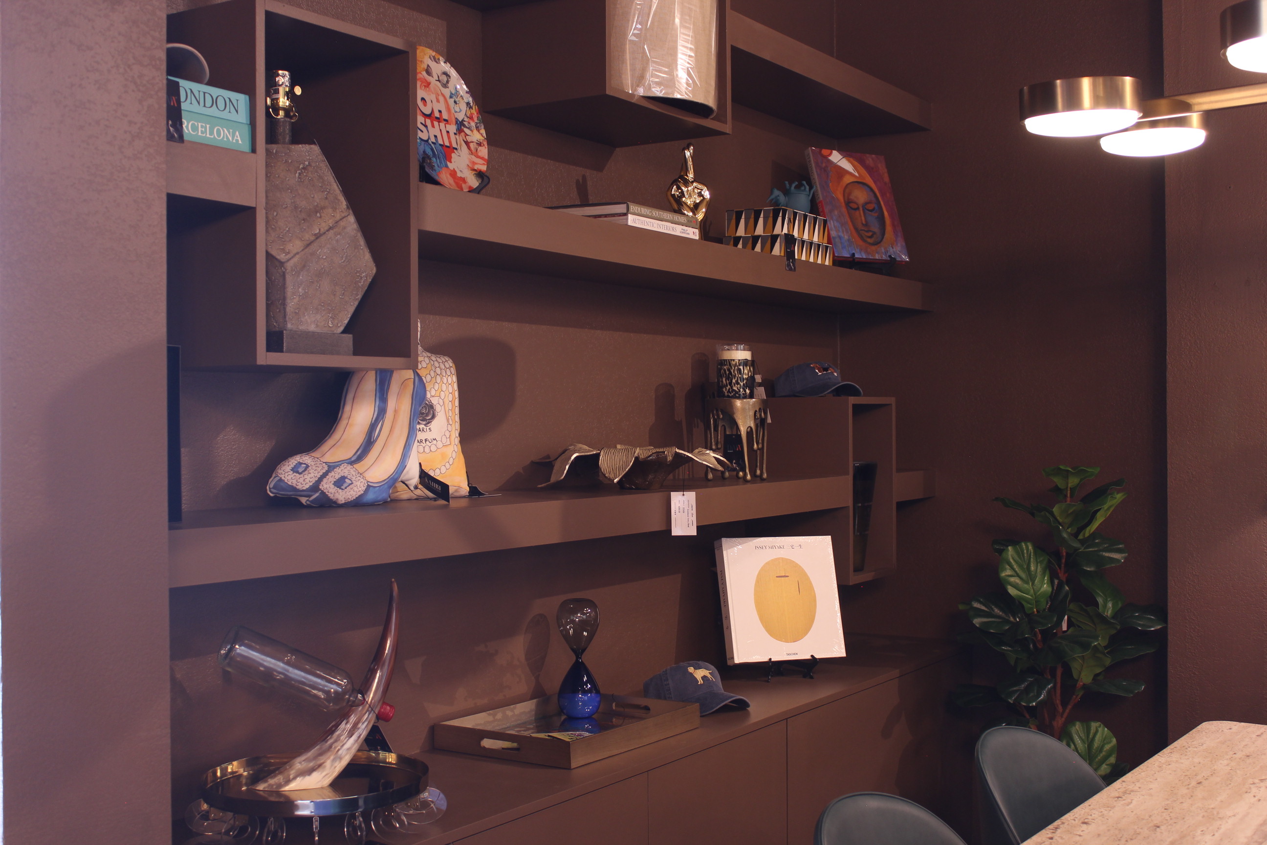 Curated art, lighting, and decorative objects displayed on shelves in the Daja showroom