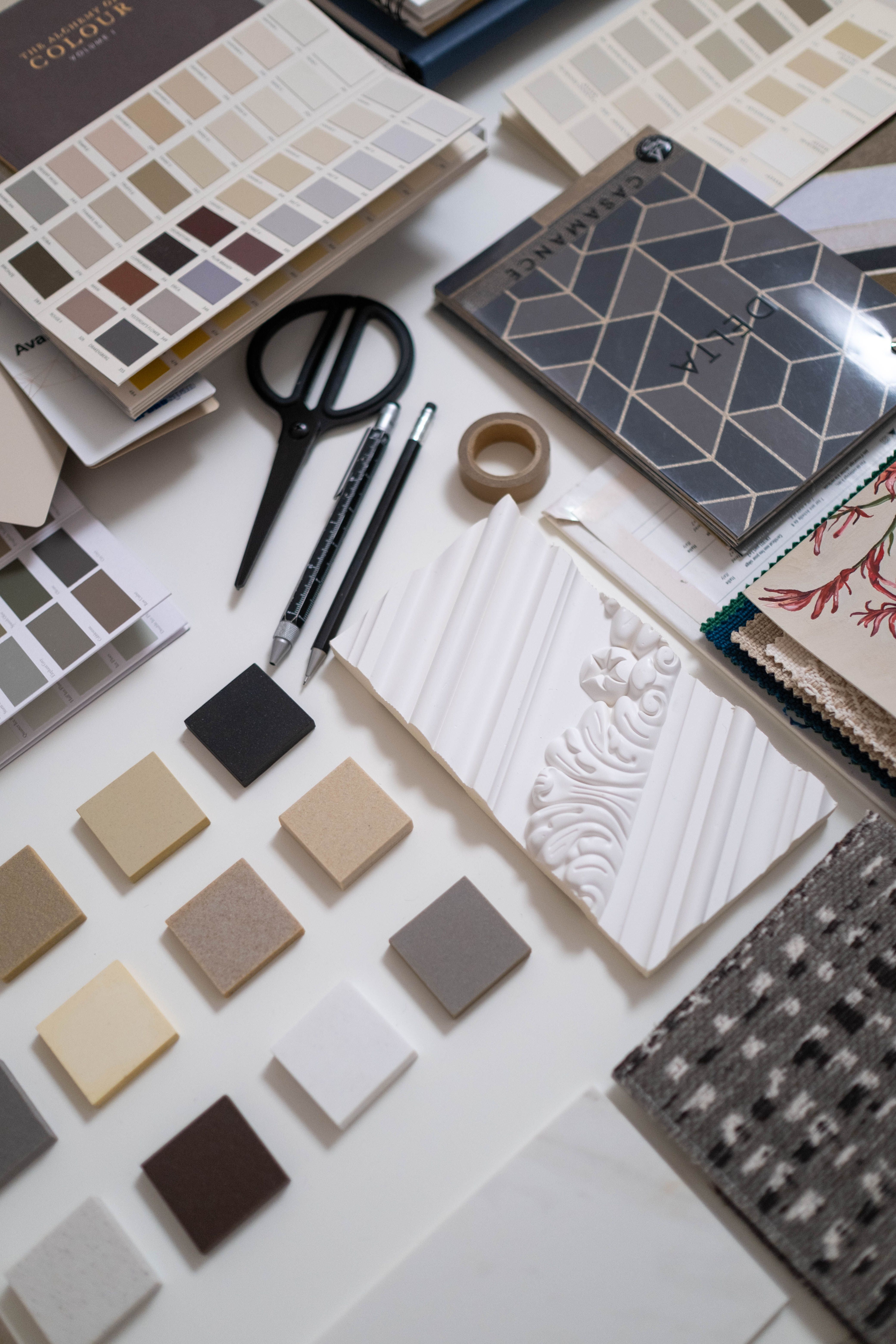 A working table arranged with material samples, color books, and design tools
